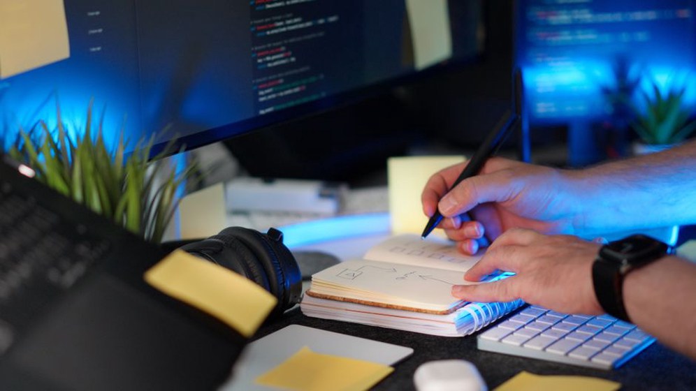 A person in a dimly lit office examines a PDF preview on an old CRT monitor