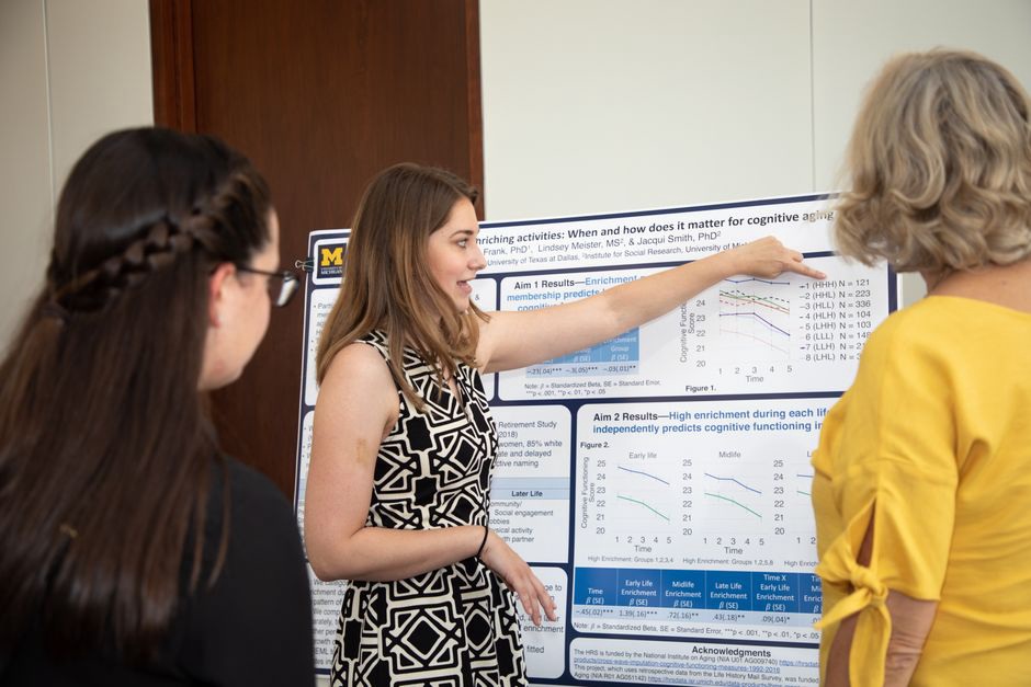 Researchers at a poster session discussing authorship contributions