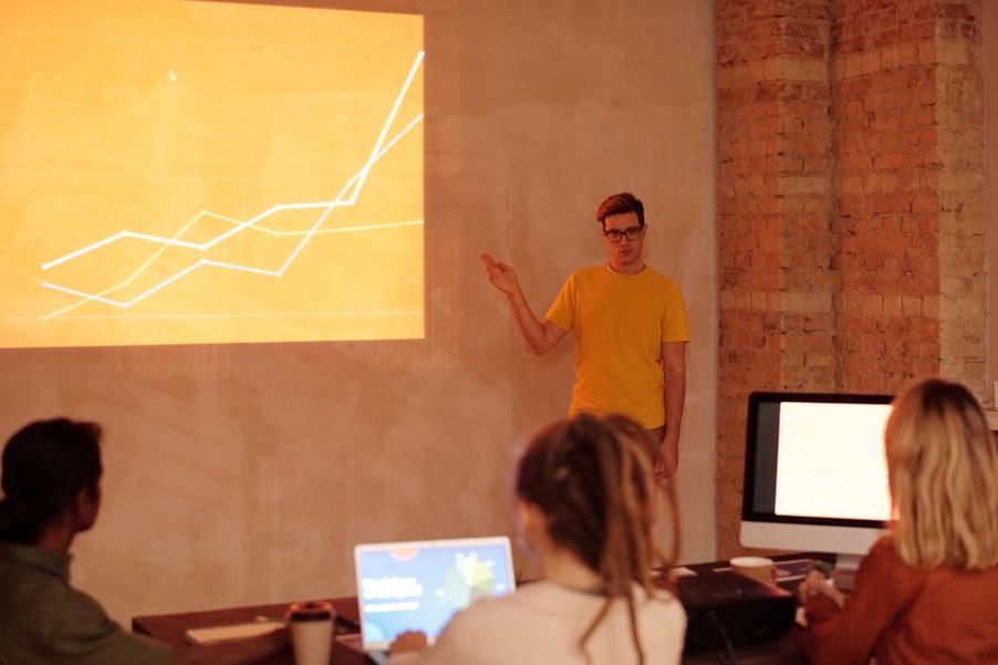 A researcher presenting slides beside a projected screen