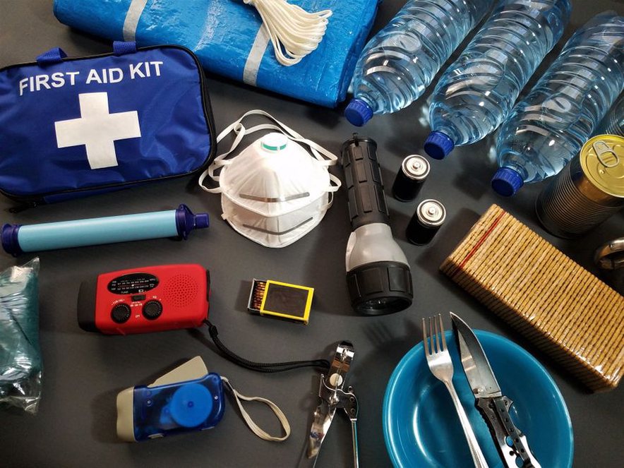 Water and ready-to-eat food arranged with household essentials