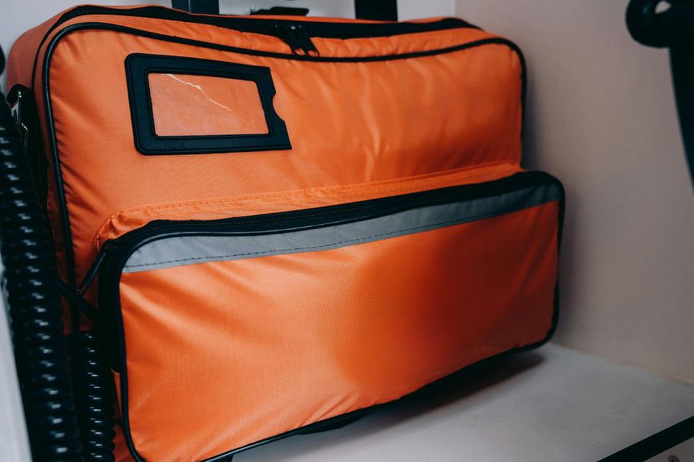 Travel bags secured beside an accessible emergency kit
