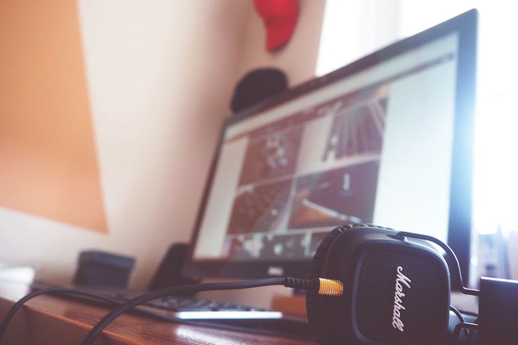Listener evaluates speech through headphones at a desk