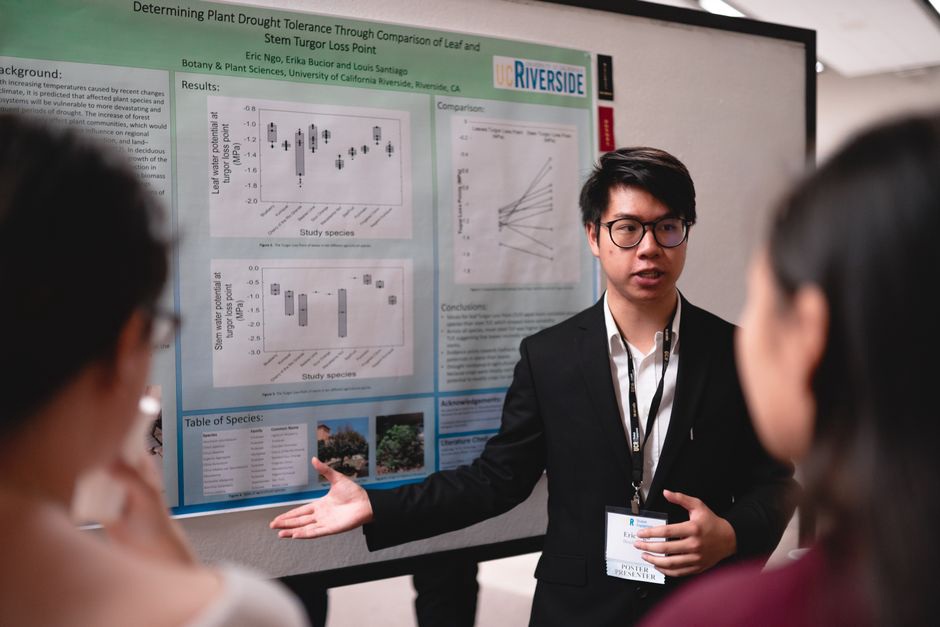 Attendees discuss results beside a research poster